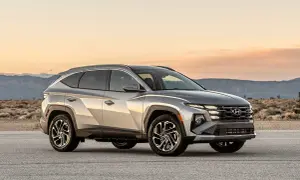 Silver Hyundai Tucson Hybrid testbil parkerad på en väg med berg i bakgrunden.