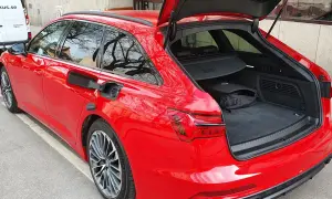 Röd Audi A6 Avant med öppet bagageutrymme. En svart väska ligger i det rymliga audi a6 bagageutrymmet.