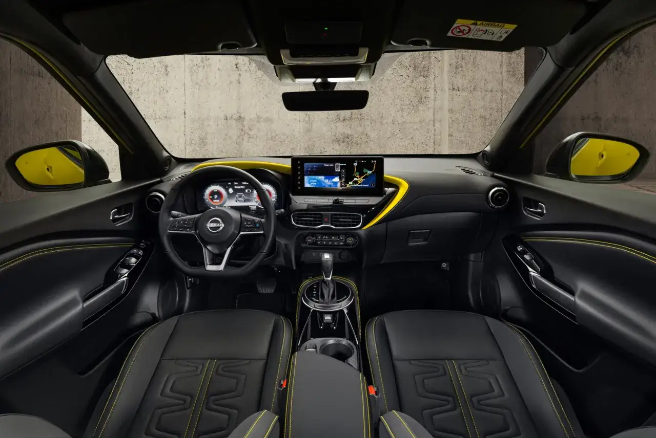 Interi&ouml;rbild av en Nissan Juke med svarta s&auml;ten och gula s&ouml;mmar. Instrumentpanelen har en stor peksk&auml;rm och digital instrumentkluster. En sp&auml;nnande Nissan Juke testk&ouml;rning v&auml;ntar!