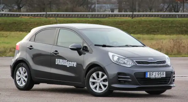 Mörkgrå Kia Rio med texten "ViBilägare" på sidan. En bil som kan ha ett kia rio problem.