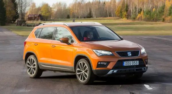 Orange Seat Ateca på en grusväg, redo för ett test. En förare syns bakom ratten.