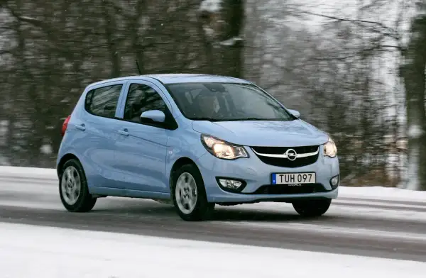 Ljusblå Opel Karl kör på en snöig väg.